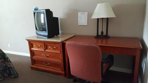 a desk with a tv on top of a dresser at Pacific Motel in Gridley
