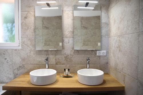 Dos lavabos en un baño con dos espejos en Résidence A Licetta, en Porto Vecchio