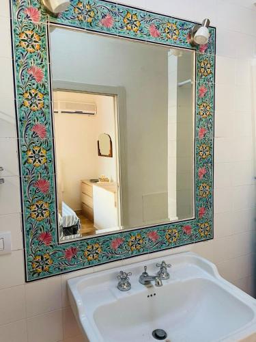 a bathroom with a sink and a large mirror at Villa vista mare a Bosa in Magomadas
