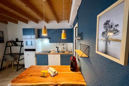 une cuisine avec des placards bleus et une table en bois dans l'établissement Duplex in chalet Gérardmer view swimming pool, à Gérardmer
