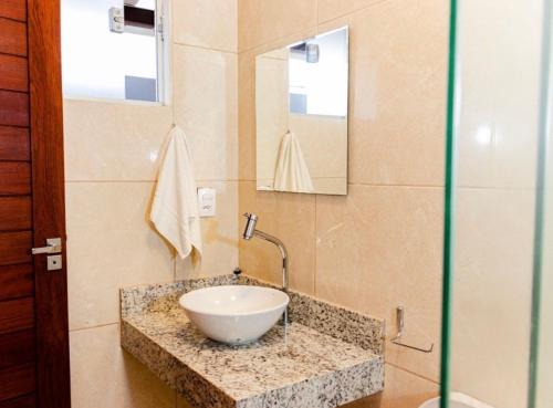 a bathroom with a bowl sink and a mirror at Pousada Luar do gostoso in São Miguel do Gostoso
