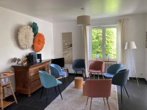 - un salon avec des chaises colorées et une table dans l'établissement Ty Boiss', à Sainte-Marine