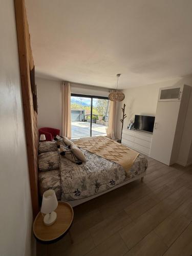 une chambre avec un lit et une grande fenêtre dans l'établissement Lodge Cosy tout confort Lodge des Oliviers, à Ganges