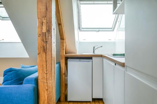 une cuisine avec un évier et un canapé bleu dans l'établissement Appartement très lumineux - vue sur la ville - 4 personnes, à Angers