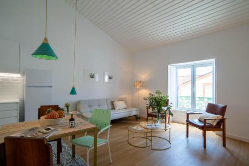 a living room with a table and chairs and a couch at Vila Marta - Garajau in Vila Franca do Campo