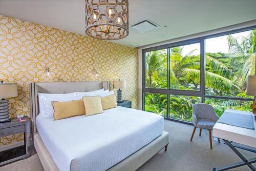 une chambre avec un lit, un bureau et des fenêtres dans l'établissement Family Fun & Luxury Andaz Penthouse Ocean & Sunset Views From Lanai Hot Tub 3 Br4 Ba For 8, à Wailea