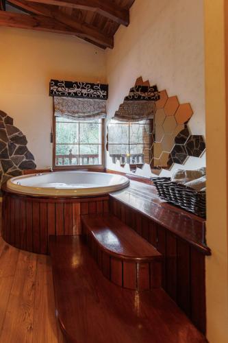 a large bath tub in a room with a window at Apartamento con jacuzzi a orillas del Río Sella in Canisquezo