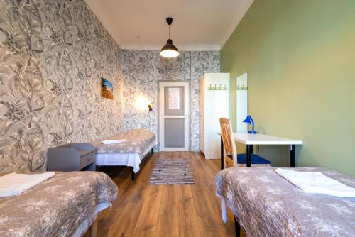 a room with three beds and a table and a desk at 16eur - Old Town Munkenhof in Tallinn