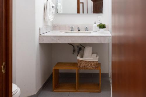 a bathroom with a sink and a stool under it at Casa Araiza in Guadalajara