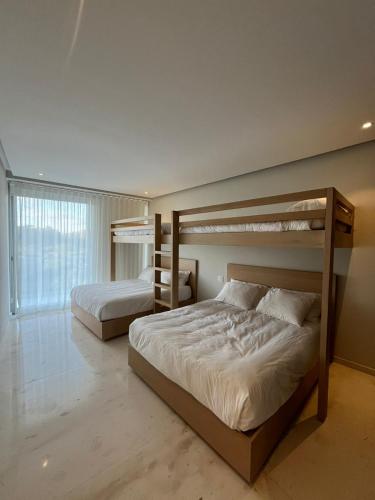 a bedroom with two bunk beds and a window at Luxury Villa in Punta Mita in Higuera Blanca