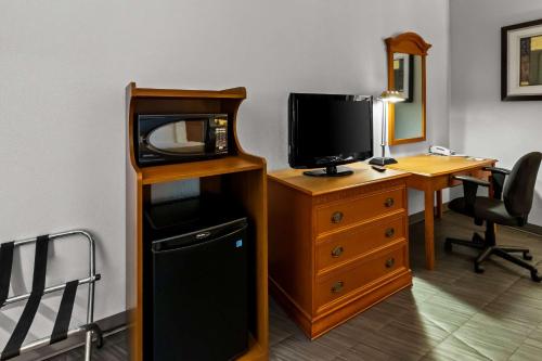 a room with a tv and a desk with a computer at Quality Inn & Suites CVG Airport in Erlanger