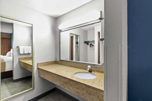 a bathroom with a sink and a mirror at Quality Inn & Suites CVG Airport in Erlanger