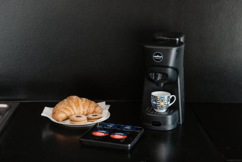 a coffee machine with a plate of pastries and a cup of coffee at Villa Da Vinci Luxury Panoramic Apartments - Taormina rooms collection in Taormina