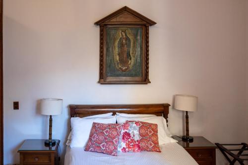 a bed with two lamps and a picture on the wall at Casa Araiza in Guadalajara