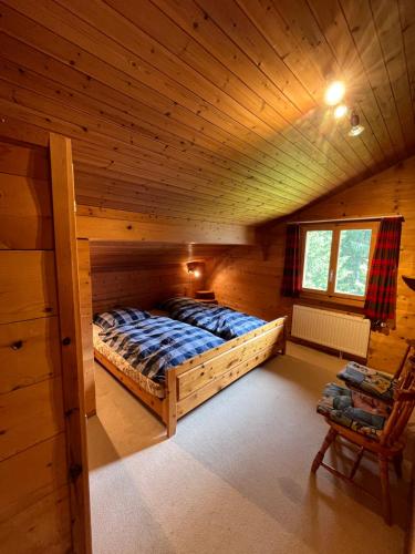 a bedroom with a bed in a wooden cabin at Chalet Karin in Sankt Niklaus