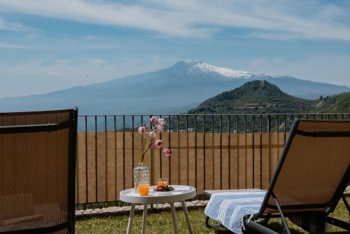 a table with a vase of flowers on a balcony at Villa Da Vinci Luxury Panoramic Apartments - Taormina rooms collection in Taormina