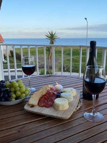 a table with a plate of food and two glasses of wine at Mountain and Ocean View in Água de Alto