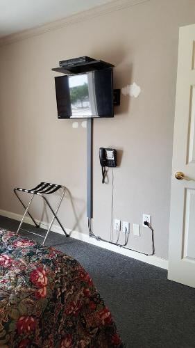 a room with a tv on the corner of a wall at Pacific Motel in Gridley
