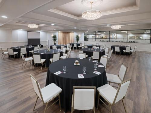 a conference room with tables and chairs and a screen at Crowne Plaza Suffern-Mahwah by IHG in Suffern