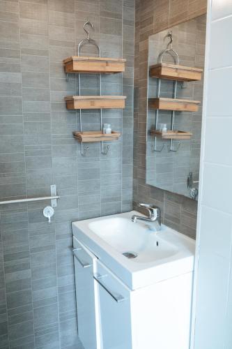 une salle de bain avec un lavabo blanc et une douche dans l'établissement T2 à 3mn du métro Mairie de Montrouge, à Montrouge