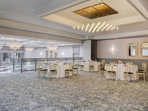 a banquet hall with tables and chairs and chandeliers at Crowne Plaza Suffern-Mahwah by IHG in Suffern