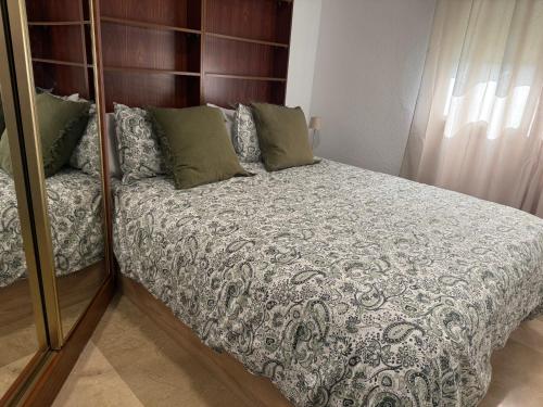 une chambre avec un lit et un miroir dans l'établissement Brisas playa y Golf, à Malaga