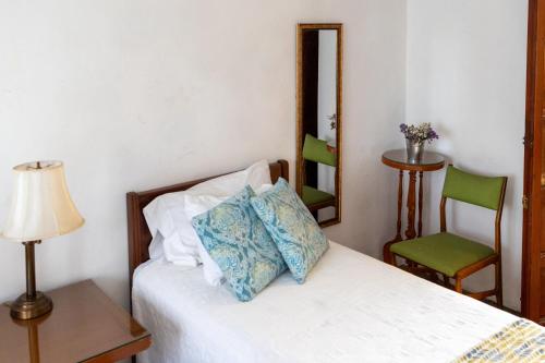 a bedroom with a bed with a lamp and a chair at Casa Araiza in Guadalajara