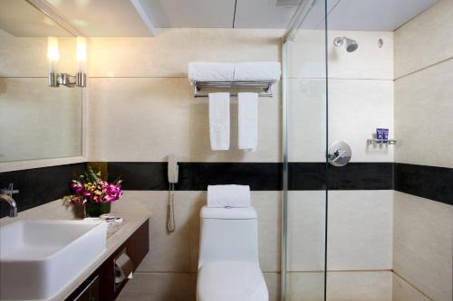 a bathroom with a toilet and a sink and a shower at Sunworld Hotel Wangfujing in Beijing
