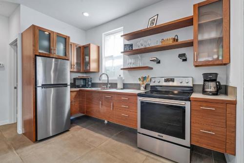 a kitchen with a stainless steel refrigerator and wooden cabinets at Lincolnville Haven l Walk to DNTN l Dog Friendly in Saint Augustine