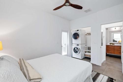 a white bedroom with a bed and a washing machine at Lincolnville Haven l Walk to DNTN l Dog Friendly in Saint Augustine