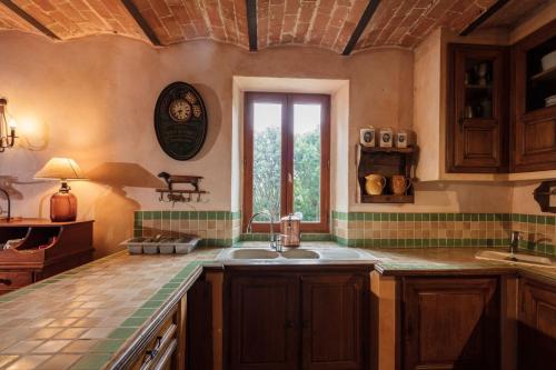 une cuisine avec un évier et une fenêtre dans l'établissement Les fermes de Rieumal Hameau Cévenol Prestige, à Lasalle