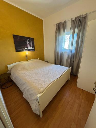 a bedroom with a large bed and a window at Apartman Kartec in Krk