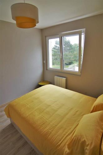 a bedroom with a large yellow bed with a window at le galet Bleu in Criel-sur-Mer