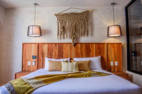 a bedroom with a large white bed with two lights at Studio in La Veleta with private rooftop in Tulum