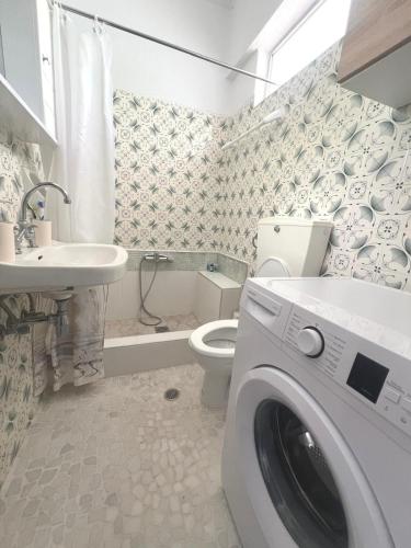 a bathroom with a washing machine and a toilet at Atlas Apartment with Private Beach and SeaView in Loutraki