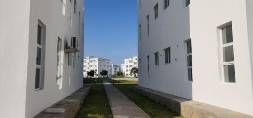 an alley between two white buildings at 1 bedroom beach apartment-Swan Homes in Malindi