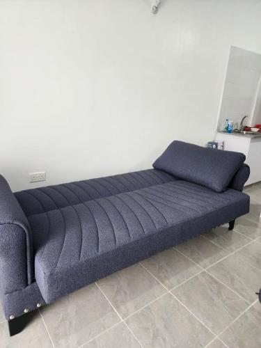 a blue couch sitting in a room at 1 bedroom beach apartment-Swan Homes in Malindi