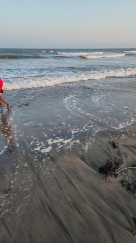 a person standing on a beach near the ocean at 1 bedroom beach apartment-Swan Homes in Malindi