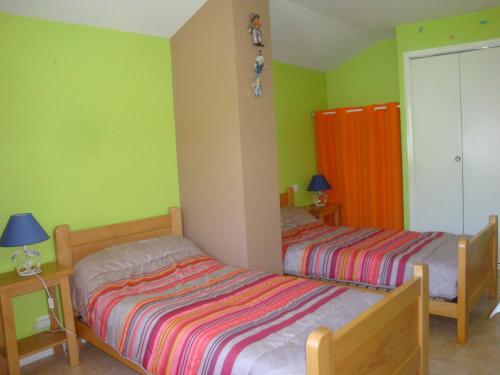 - 2 lits dans une chambre aux murs verts et orange dans l'établissement Grand Gite, à La Celle-sous-Gouzon