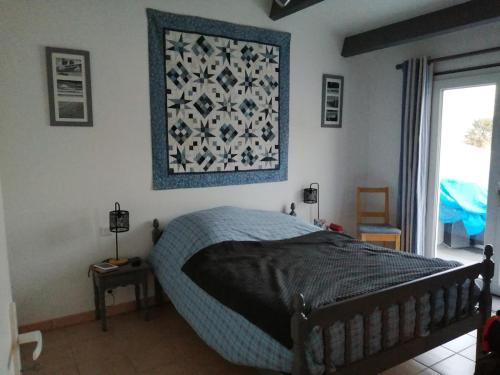 une chambre avec un lit et un tableau au mur dans l'établissement Maison dans un village boiséprès de la plage, à La Celle-sous-Gouzon