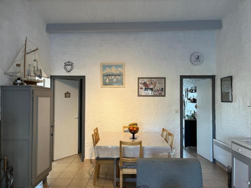 une cuisine et une salle à manger avec une table et des chaises dans l'établissement Maison dans un village boiséprès de la plage, à La Celle-sous-Gouzon