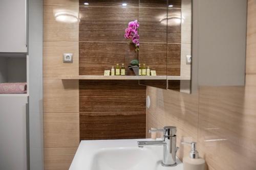 a bathroom with a sink and a flower on the wall at Apartments Ariana in Umag