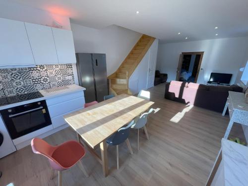 a kitchen and living room with a table and chairs at Duplex Vittel Centre Ville in Vittel