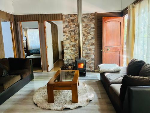 a living room with a couch and a wood stove at La Escondida de Vilches in Talca