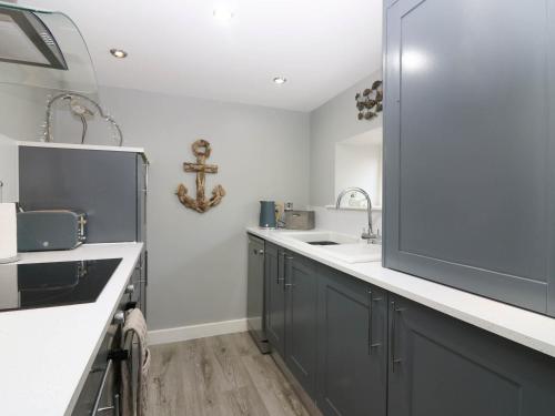 a kitchen with blue cabinets and a sink at 61 Seatown in Buckie