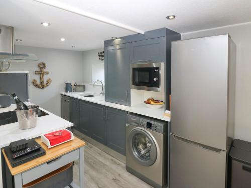 a kitchen with a refrigerator and a washing machine at 61 Seatown in Buckie