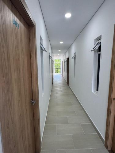 a corridor of a hallway with a door and a tile floor at Angel Mari a Doradal in Doradal