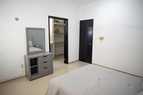 a bedroom with a mirror and a bed and a dresser at Modern villa with private pool, 1 block from the Ocean in Chicxulub