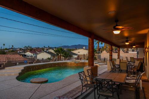 a patio with a table and chairs and a swimming pool at Havasu River Stay Pool Spa OutdoorTV Views in Lake Havasu City