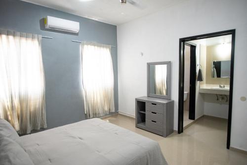 a bedroom with a bed and a mirror and a sink at Modern villa with private pool, 1 block from the Ocean in Chicxulub